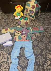 a toddler's outfit with a stuffed animal and a toy on the floor